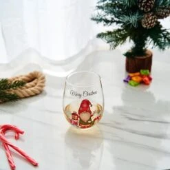 Stemless Christmas Gnome Wine Glass - SINGLE Red Green Cheer For Holiday Gift And Winter Season - 17 Oz Stemless Decorated Ornament Wine Tumblers For Holiday Season And Winter By GUTE - 4.7" H 7 Stemless Christmas Gnome Wine Glass - SINGLE Red Green Cheer For Holiday Gift And Winter Season - 17 Oz Stemless Decorated Ornament Wine Tumblers For Holiday Season And Winter By GUTE - 4.7" H -Refined Spirits Store T9238 8524 stemlesswinesantagnomewithpresentssinglelifestyle